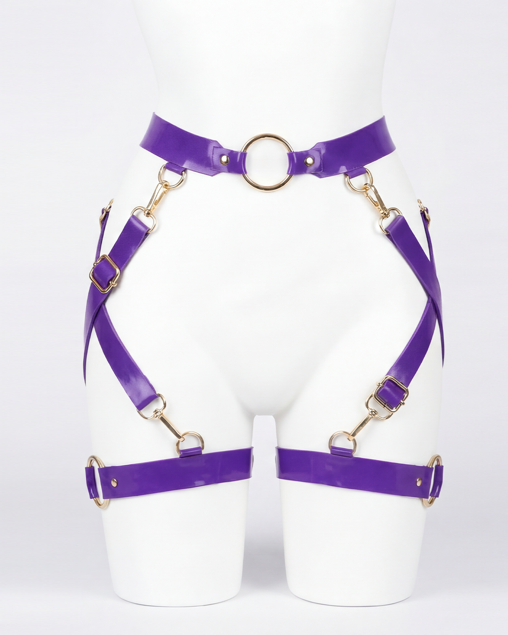 A glossy purple latex waist and leg harness set by Ribcage, featuring structural straps, metallic O-rings, and adjustable buckles.