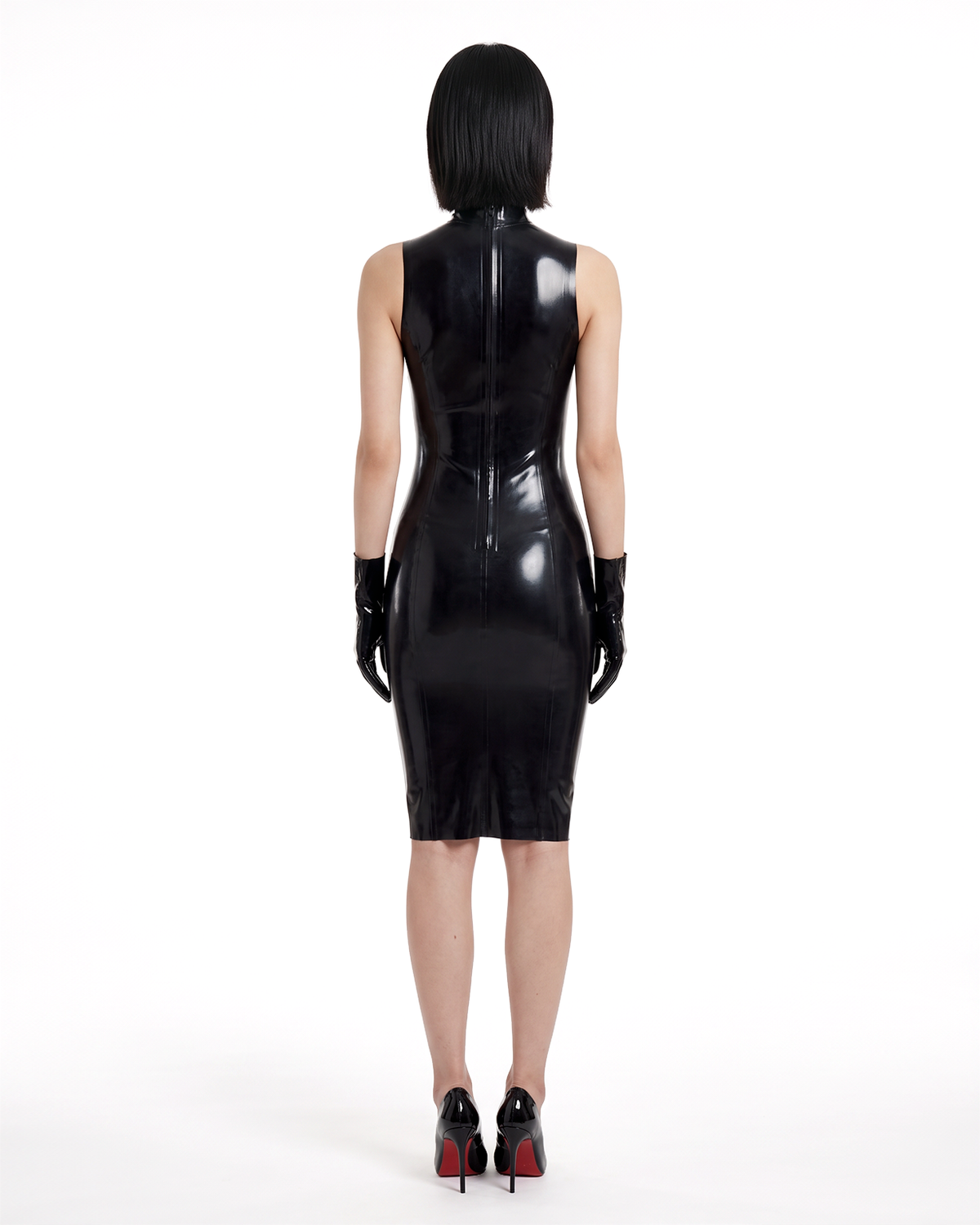 A model shown from the back wearing the high-shine black latex The Arbiter Dress by Ribcage Latex, featuring contoured seaming, a half-length back zipper, and a knee-length compressive cut.