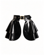 A glossy black latex peplum overlay belt by Ribcage, featuring a structured waist belt with a gold metallic buckle, hardware rings, and a double-layer flounce peplum