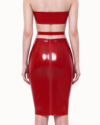 A model shown from the back wearing a high-shine red latex high-waisted pencil skirt by Ribcage, featuring a contrasting waistline design and a full-length back zipper closure, styled with a matching strapless bandeau top.