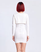 A model shown from the back wearing a high-shine white latex two-piece ensemble by Ribcage, featuring a minimalist spaghetti strap cami dress, a structured long-sleeve bolero, and a compressive second-skin fit.