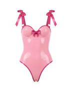 A metallic pink latex bodysuit by Ribcage, featuring a sweetheart neckline with a center bow, structured bow shoulder straps, and a high-cut leg silhouette.