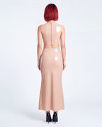 A model shown from the back wearing a high-shine nude latex two-piece ensemble by Ribcage, featuring a minimalist sleeveless crop top, a high-waisted maxi skirt, and a compressive second-skin fit.