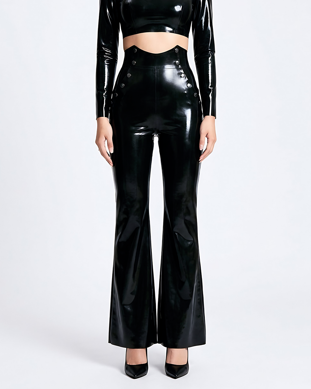 A model shown from the front wearing a pair of glossy metallic black latex high-waisted flared trousers by Ribcage, featuring a sharp architectural drape, distinctive side button details, and a compressive second-skin fit.
