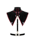 A glossy black latex modular capelet harness set by Ribcage, featuring a high-neck triangular capelet with contrast red trim, a vertical chest strap, and a waist belt with metallic O-rings.